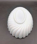 Parte inferior decorada de bandeja ovalada de opalina blanca con diseño en espiral, perfecta para tocador o colección antigua.