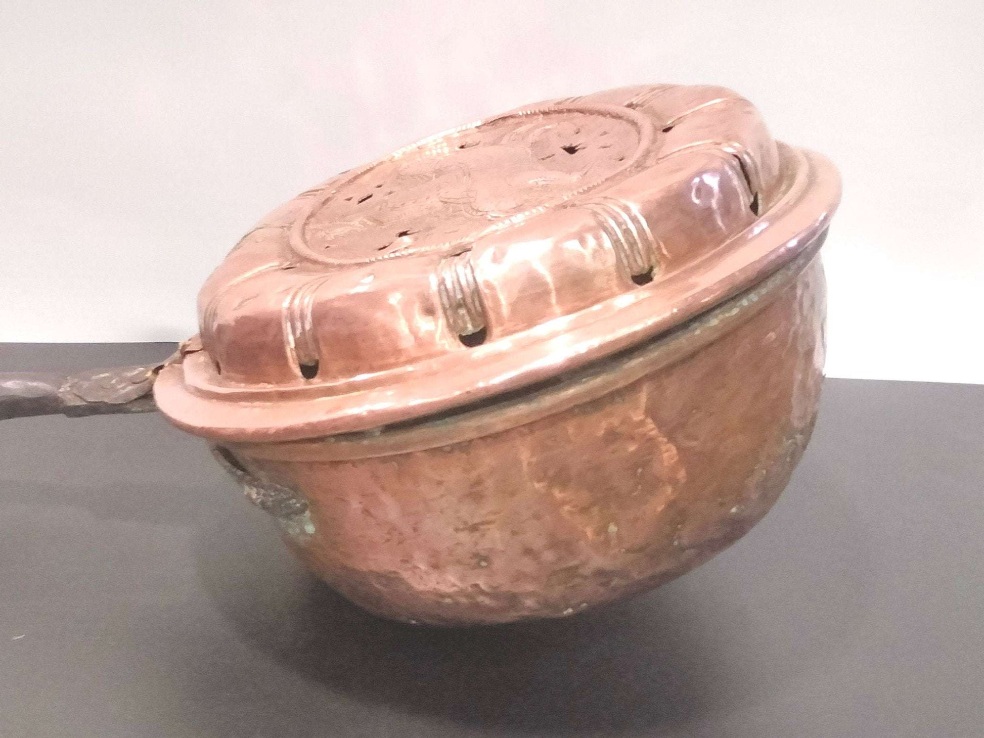 Calienta camas de cobre repujado antiguo con tapa decorativa perforada, ideal para decoración vintage en el hogar. Artículo exclusivo de colección.