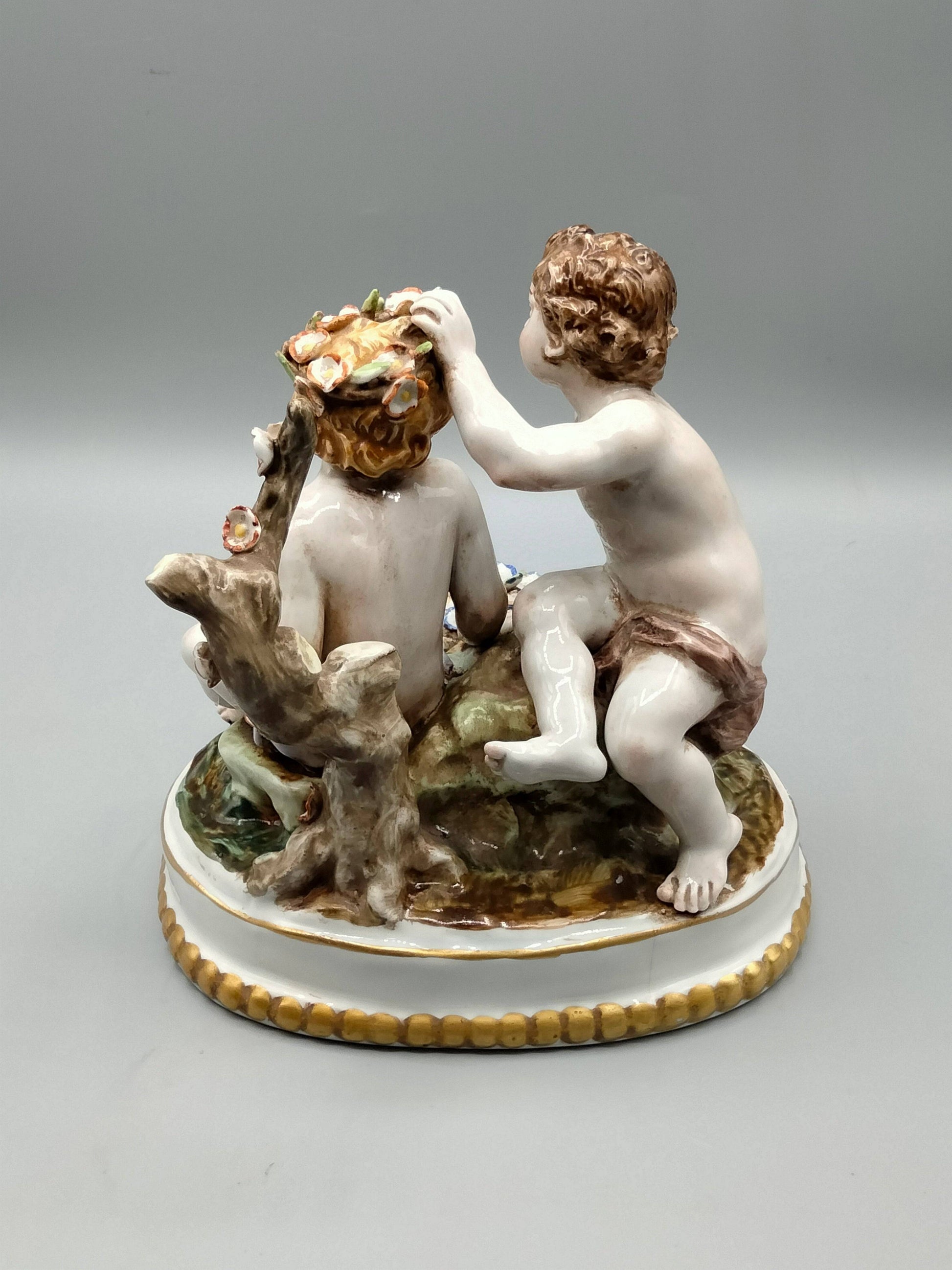 Vista trasera de figura de porcelana Hispania Manises, niños jugando con flores y detalles artesanales, ideal para decoración clásica.