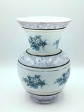 Jarrón de opalina antiguo con diseño floral azul pintado a mano, acabado en blanco con detalles dorados. Ideal para decoración elegante de interiores.