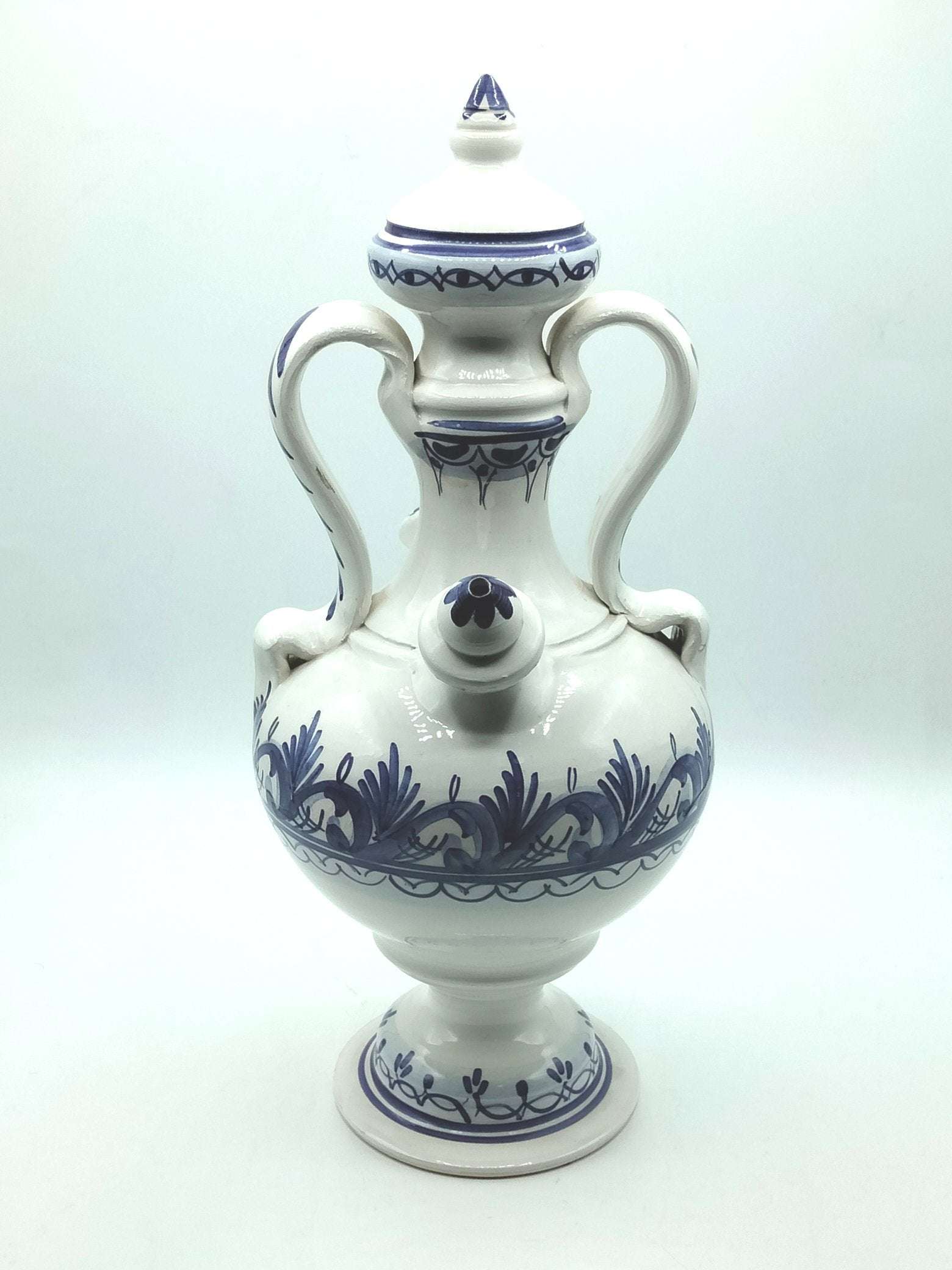 Botijo artesanal azul de cerámica esmaltada con detalles pintados a mano, ideal para decoración de interiores. Diseño único y tradicional.
