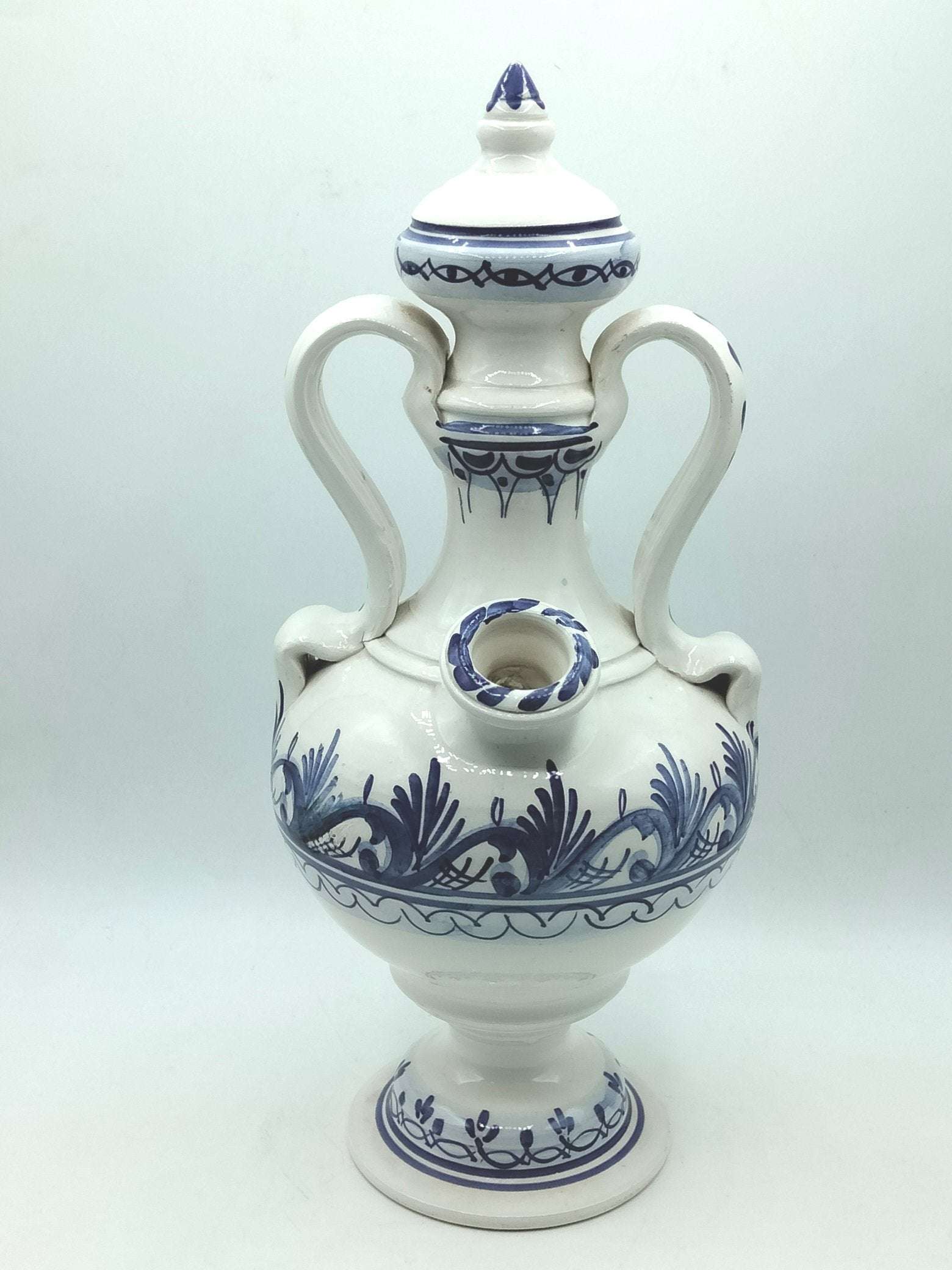 Botijo artesanal azul de cerámica esmaltada con detalles pintados a mano, ideal para decoración de interiores en estilo tradicional y rústico.