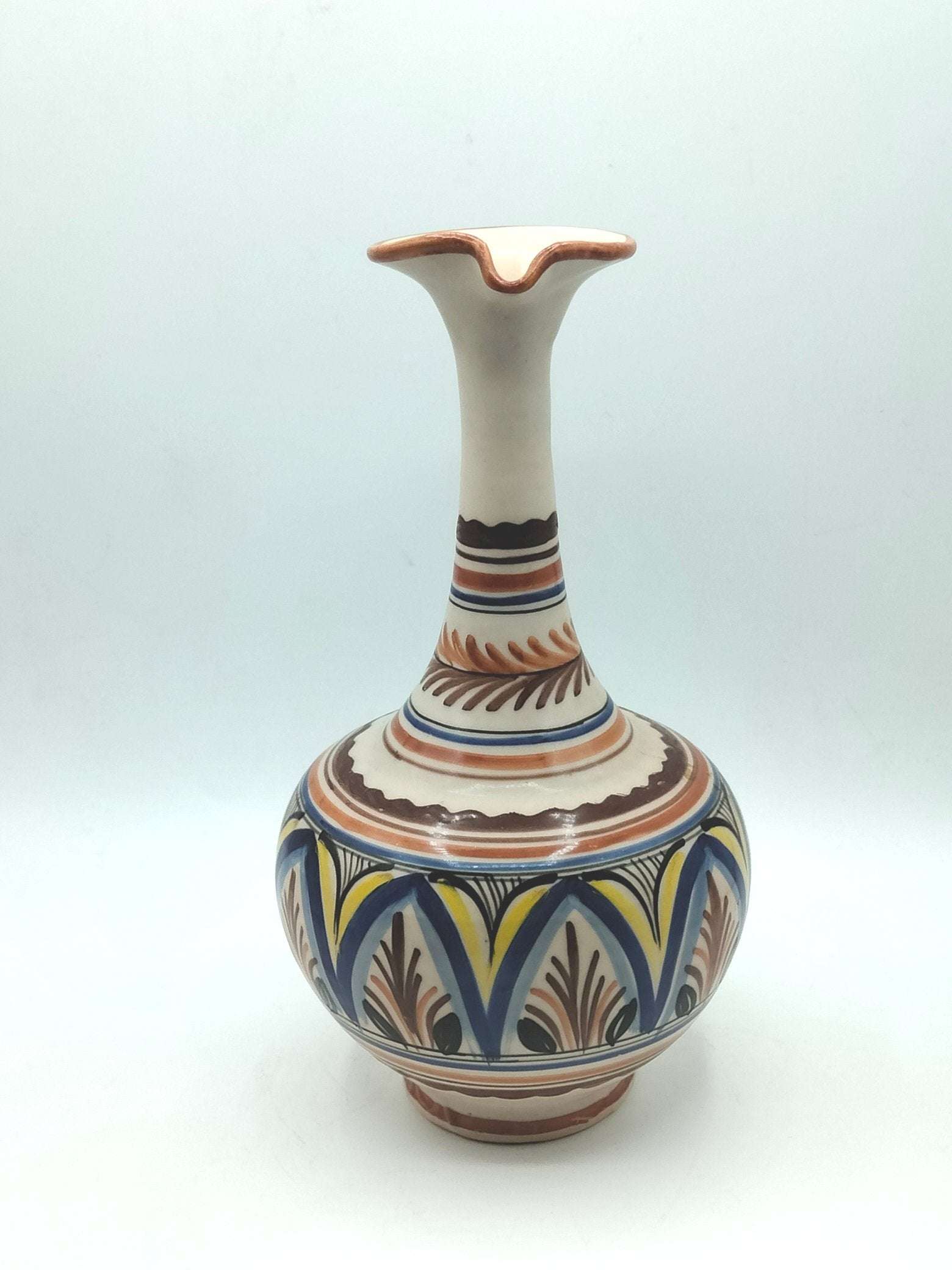 Jarra ceramica artesanal con diseño elegante pintado a mano en tonos tierra, azul y amarillo. Ideal para decoración de interiores en estilo rústico.