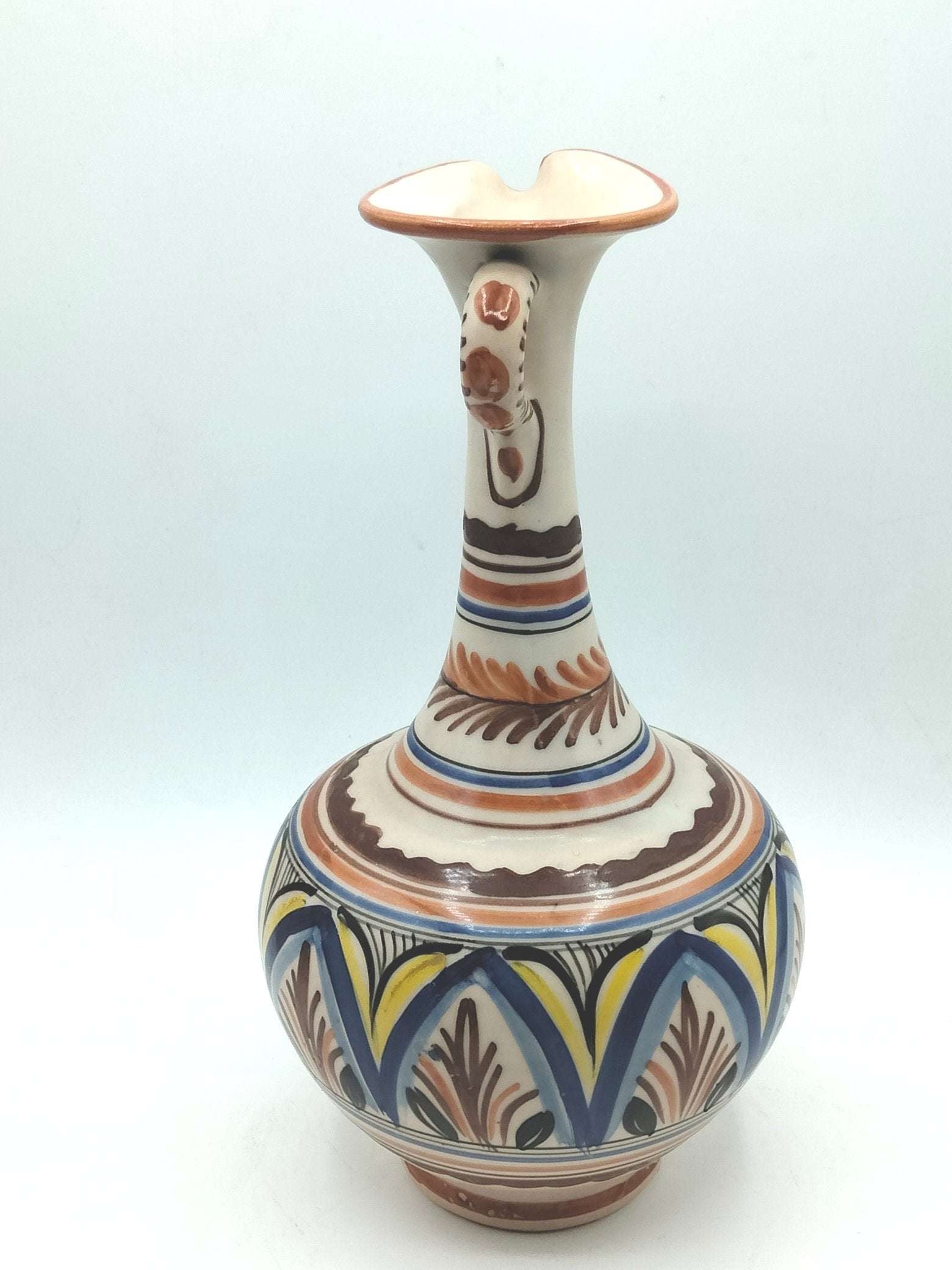 Jarra ceramica artesanal con diseño elegante pintado a mano, colores tierra, azul y amarillo. Ideal para decoración de interiores en hogar moderno.
