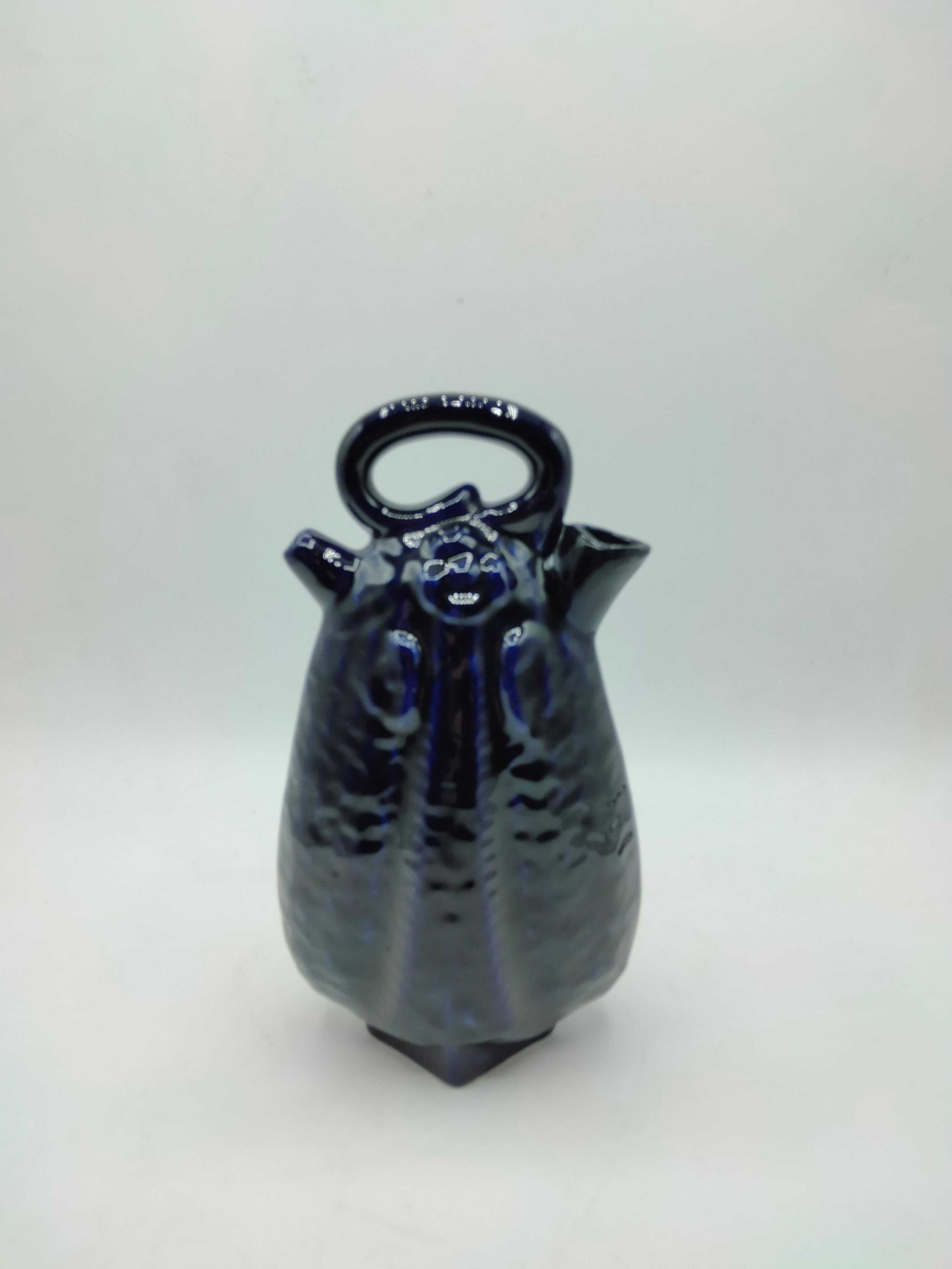 Otijo artesanal de cerámica azul con acabado brillante y diseño elegante, ideal para decoración de interiores. Calidad excepcional y estilo único.
