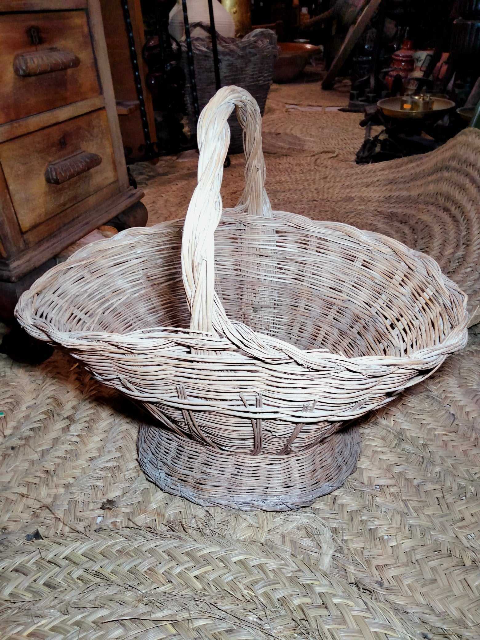Cesteria de mimbre artesanal para flores con asa trenzada, ideal para decoración rústica en bodas y eventos. Cesta versátil para el hogar.