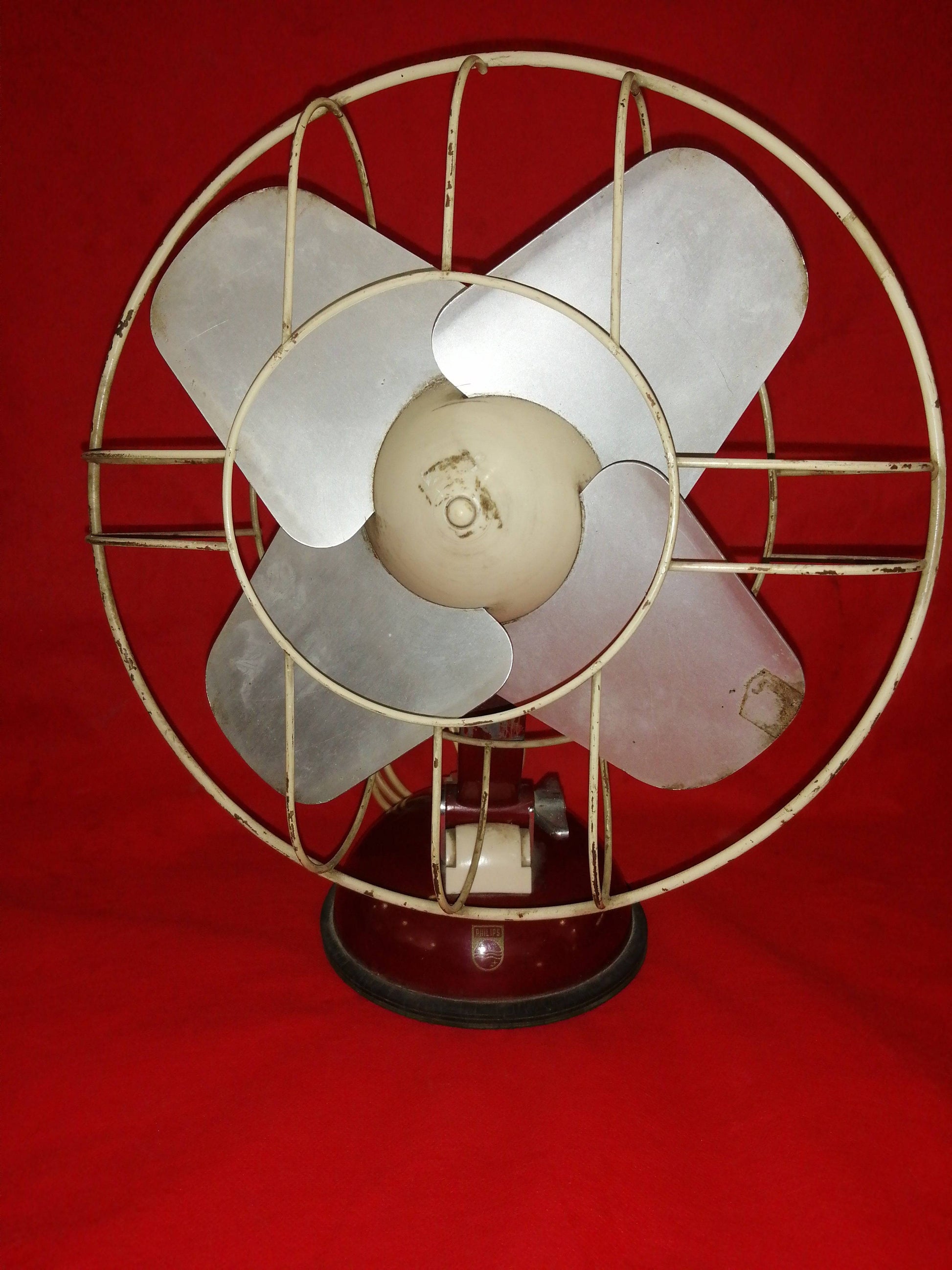 Ventilador Antiguo Philips 125V con diseño vintage en metal y base oscura, ideal para decoración retro en el hogar o jardín.