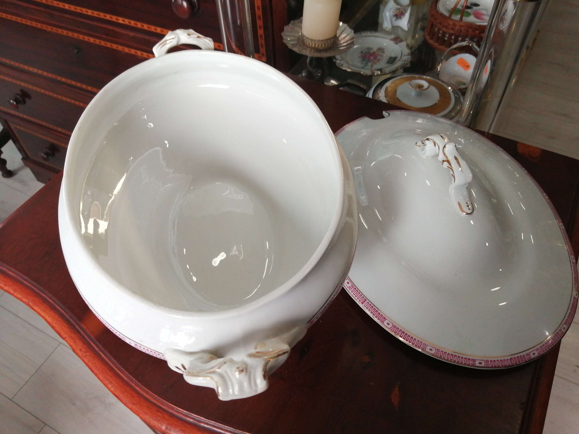 Fuente de porcelana con tapa, diseño clásico con asas ornamentadas y borde decorativo rosa. Ideal para decoración elegante en el hogar.