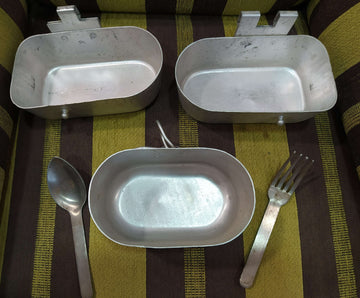 Fiambrera de aluminio antigua militar con cubiertos incluidos, ideal para decoración vintage en hogar o jardín. Incluye cuchara y tenedor metálicos.