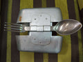 Fiambrera de aluminio antigua militar con cubiertos incluidos, ideal para decoración vintage en hogar o jardín. Diseño robusto y funcional.