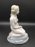 Vista lateral de la figura de La Sirenita de porcelana, mostrando detalles delicados y elegancia clásica desnuda, perfecta para coleccionistas.