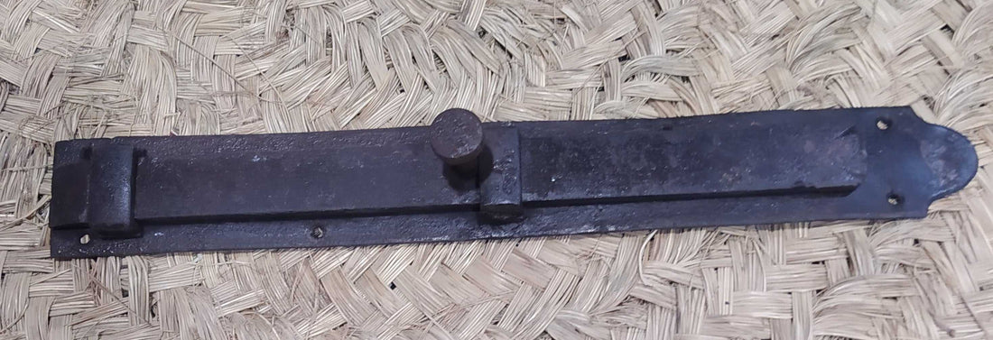 Pestillo central para puerta de hierro forjado con diseño antiguo, ideal para decoración rústica y seguridad en el hogar.