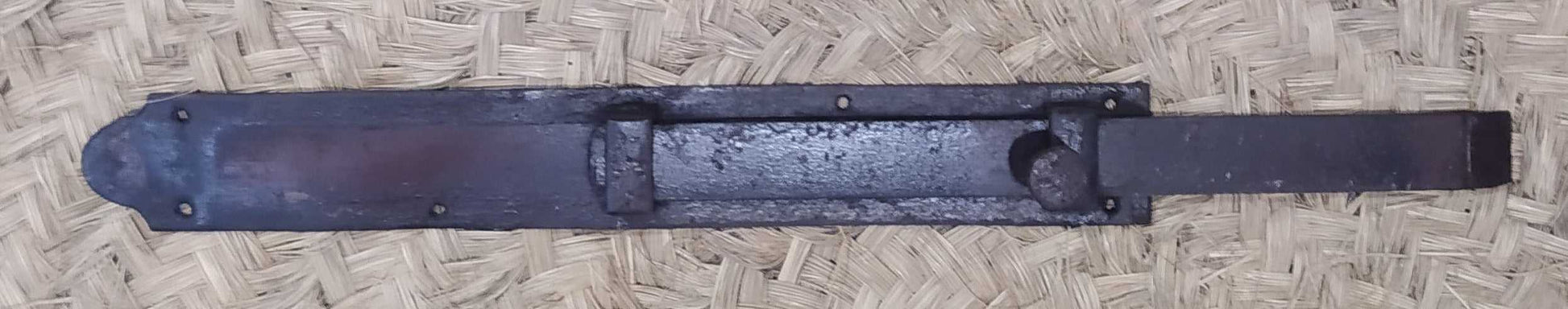Pestillo central para puerta de hierro forjado con diseño antiguo, ideal para decoración rústica y seguridad en portones o puertas interiores.