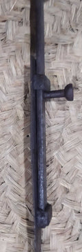 Pestillo central para puerta de hierro forjado con diseño antiguo, ideal para decoración rústica y seguridad en portones de madera.