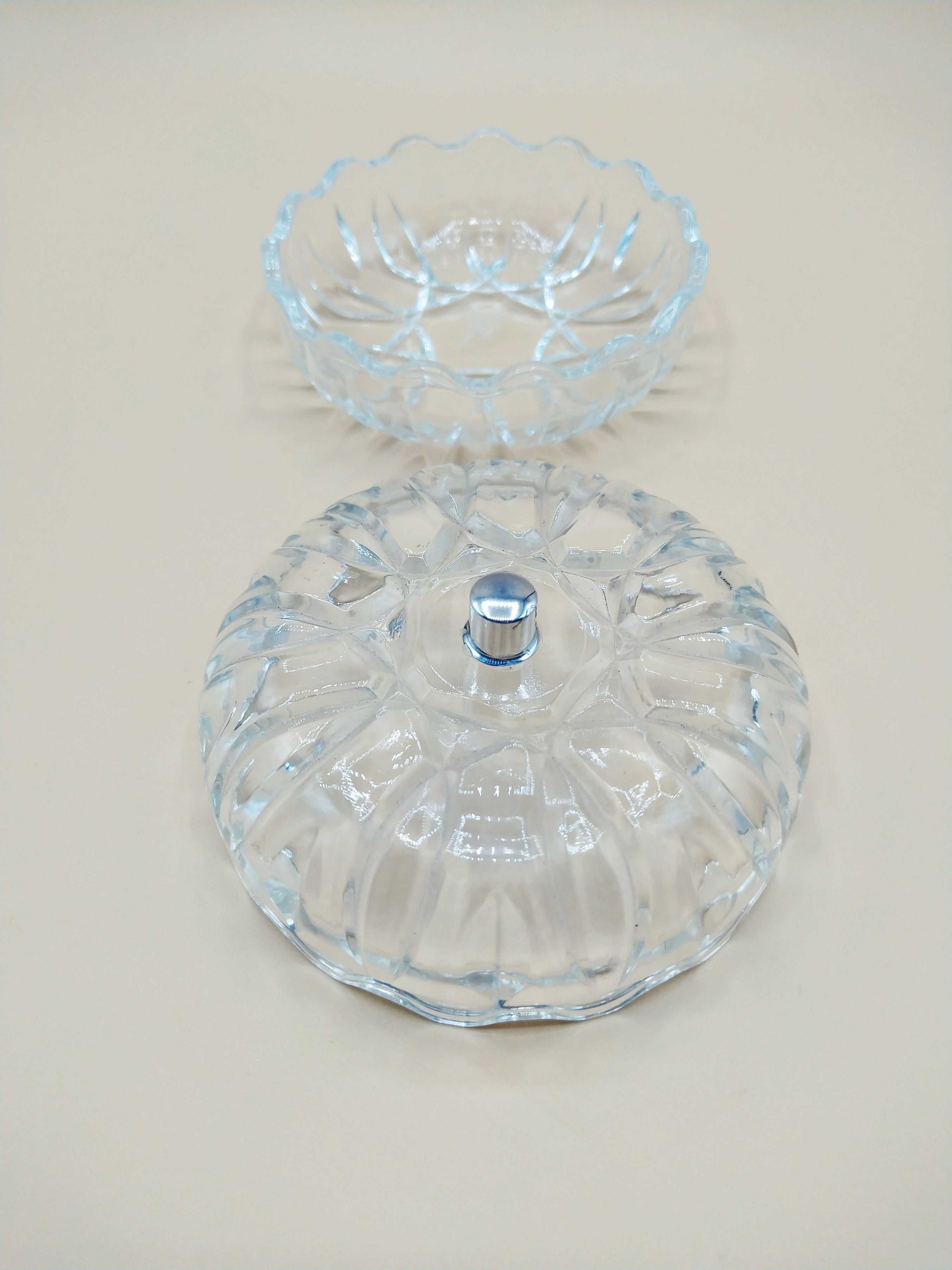Caja-joyero de cristal con tirador de plata, diseño tallado y forma redonda, ideal para decoración elegante en el hogar.