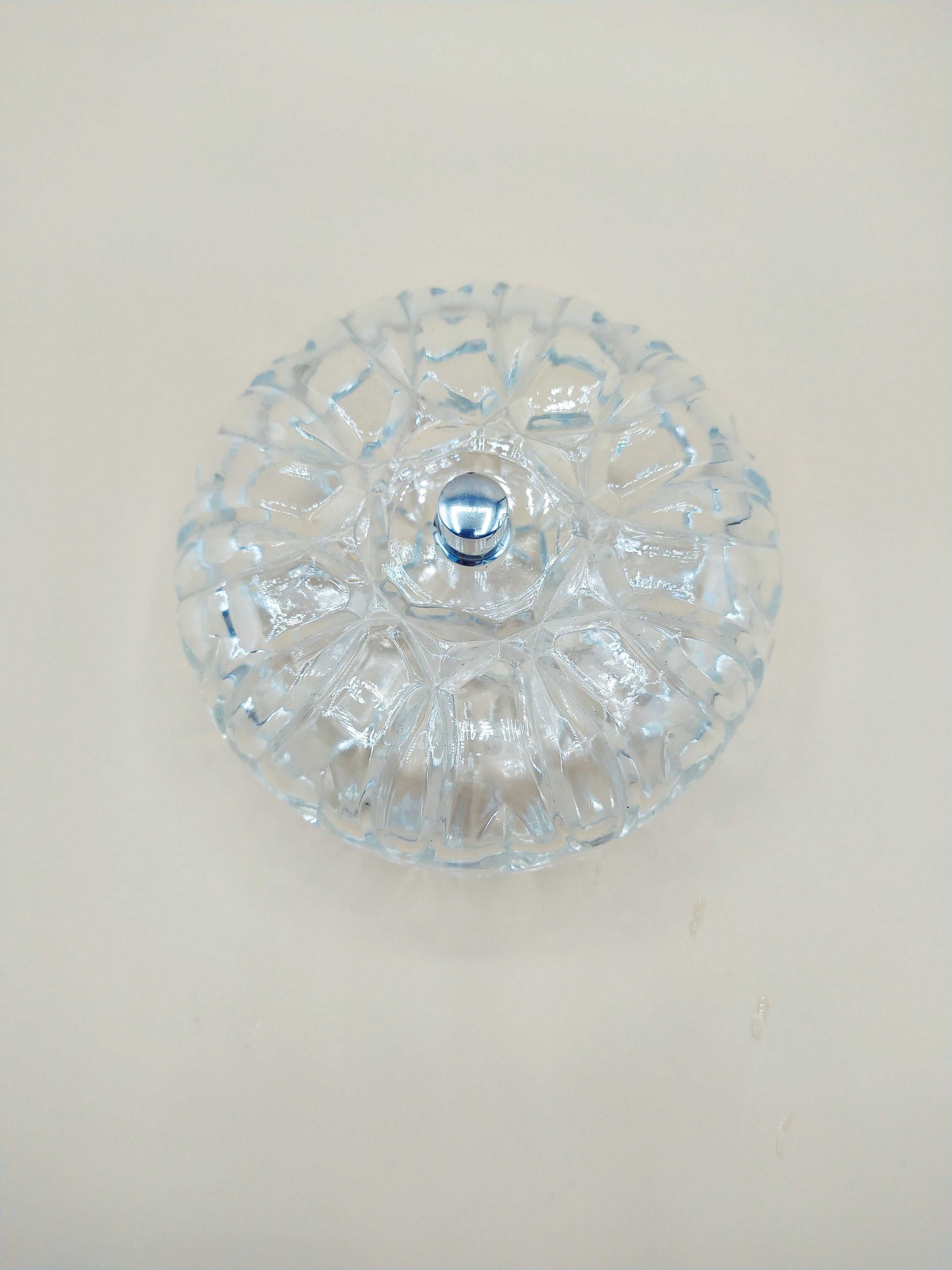 Caja-joyero de cristal con tirador de plata, diseño tallado en forma circular ideal para decoración elegante en el hogar. Perfecta para organizar joyas con estilo.