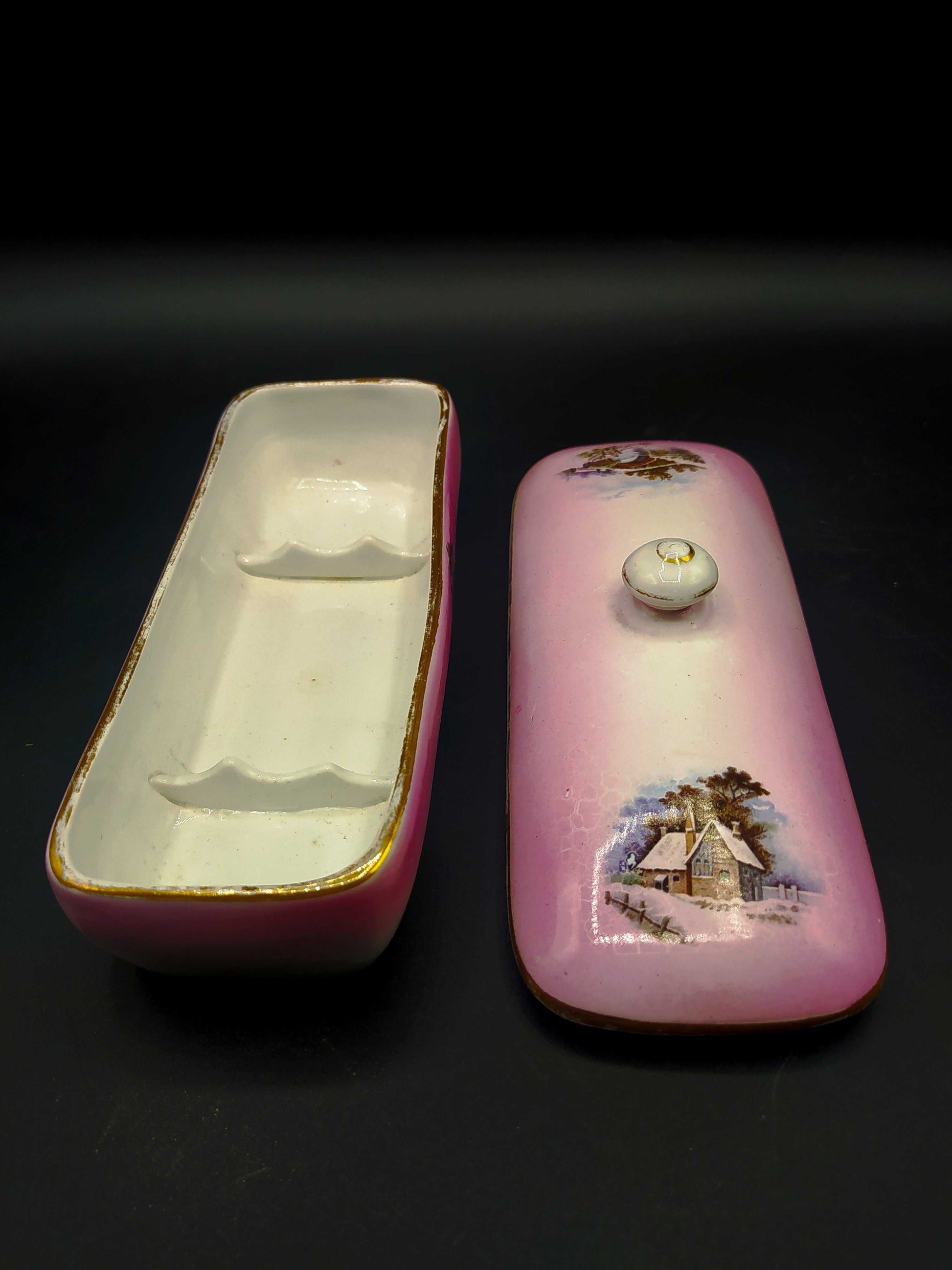 Tarro de tocador rectangular en porcelana Cartuja de Sevilla, decorado en rosa con escena campestre y detalles dorados. Ideal para decoración vintage.