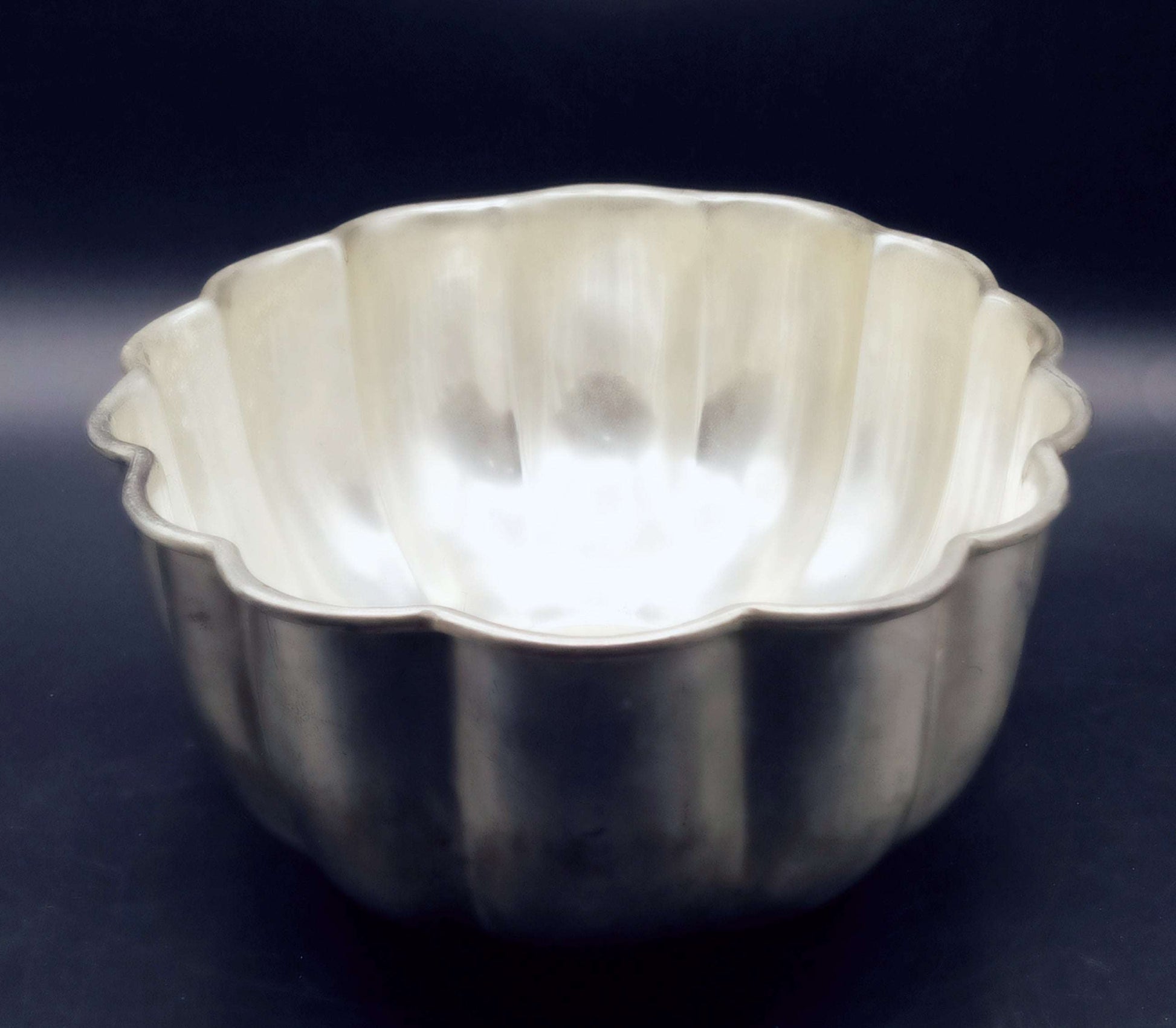 Centro floral de metal plateado mate con forma acanalada, ideal para decoraciones vintage en el hogar. Hecho en alpaca de alta calidad, 27x21x10 cm.