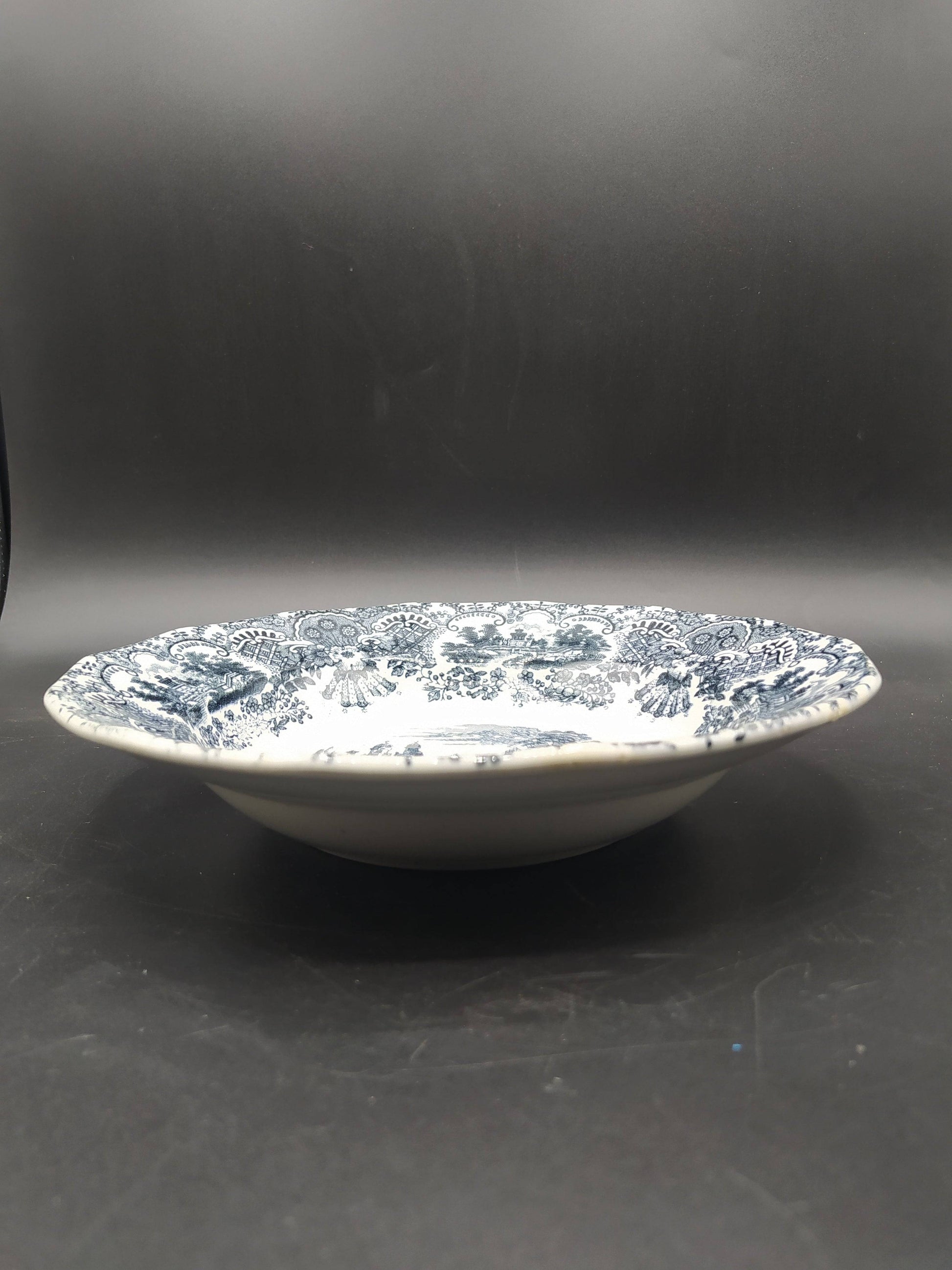Plato hondo de porcelana La Cartuja, modelo vistas, siglo XIX, con decoración en negro sobre fondo blanco. Ideal para decoración vintage de hogar.