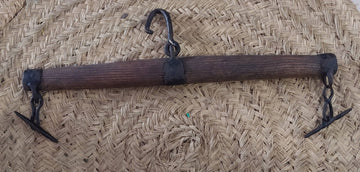 Balancín de madera dura para tiro animal con gancho central y extremos metálicos, ideal para mulas y caballos en decoración rústica.