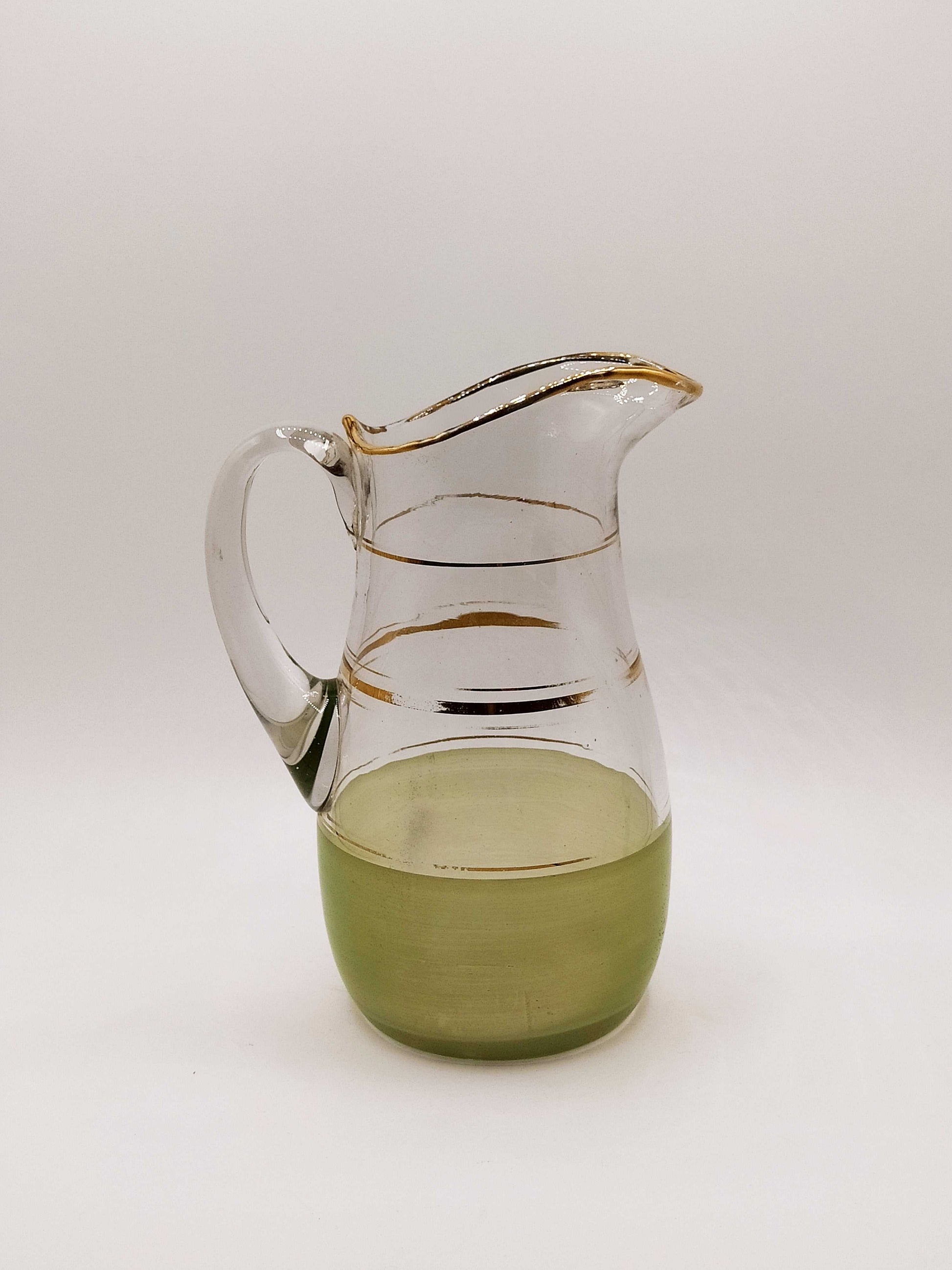 Jarra de cristal verde mate y dorado con diseño vintage, ideal para decoración elegante en el hogar. Pieza de colección para amantes de la cristalería.