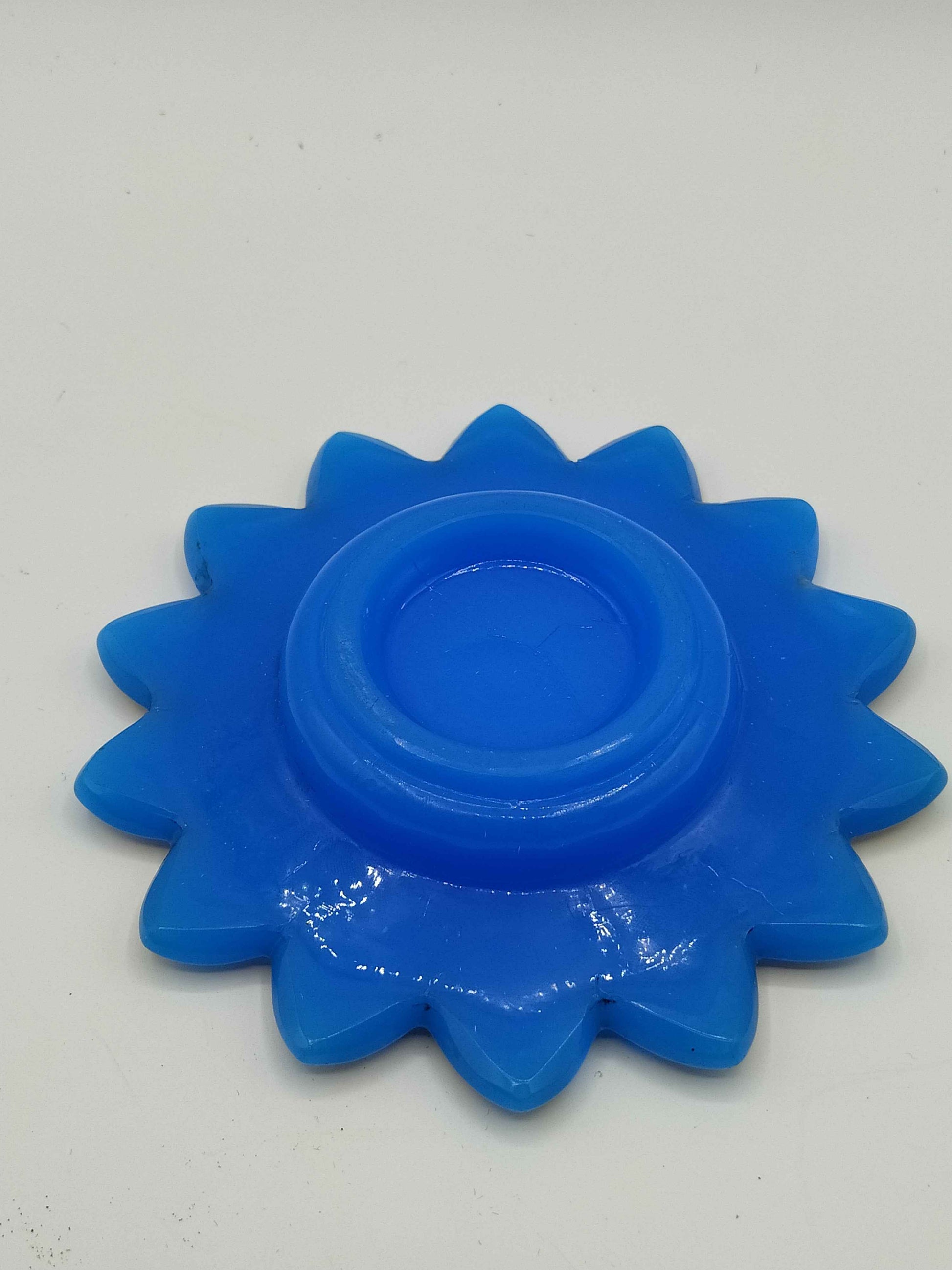 Plato de opalina azul con forma de flor y decorado dorado ausente, ideal para decoración elegante en el hogar. Calidad premium, 14 cm de diámetro.