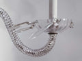 Detalle de antigua pareja de apliques de cristal de roca y metal electrificados con brazo curvo y colgantes decorativos. Ideal para iluminación de lujo.
