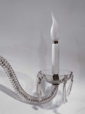 Antigua pareja de apliques de cristal de roca y metal electrificados con brazo curvo y colgantes decorativos. Diseño clásico ideal para interiores elegantes.