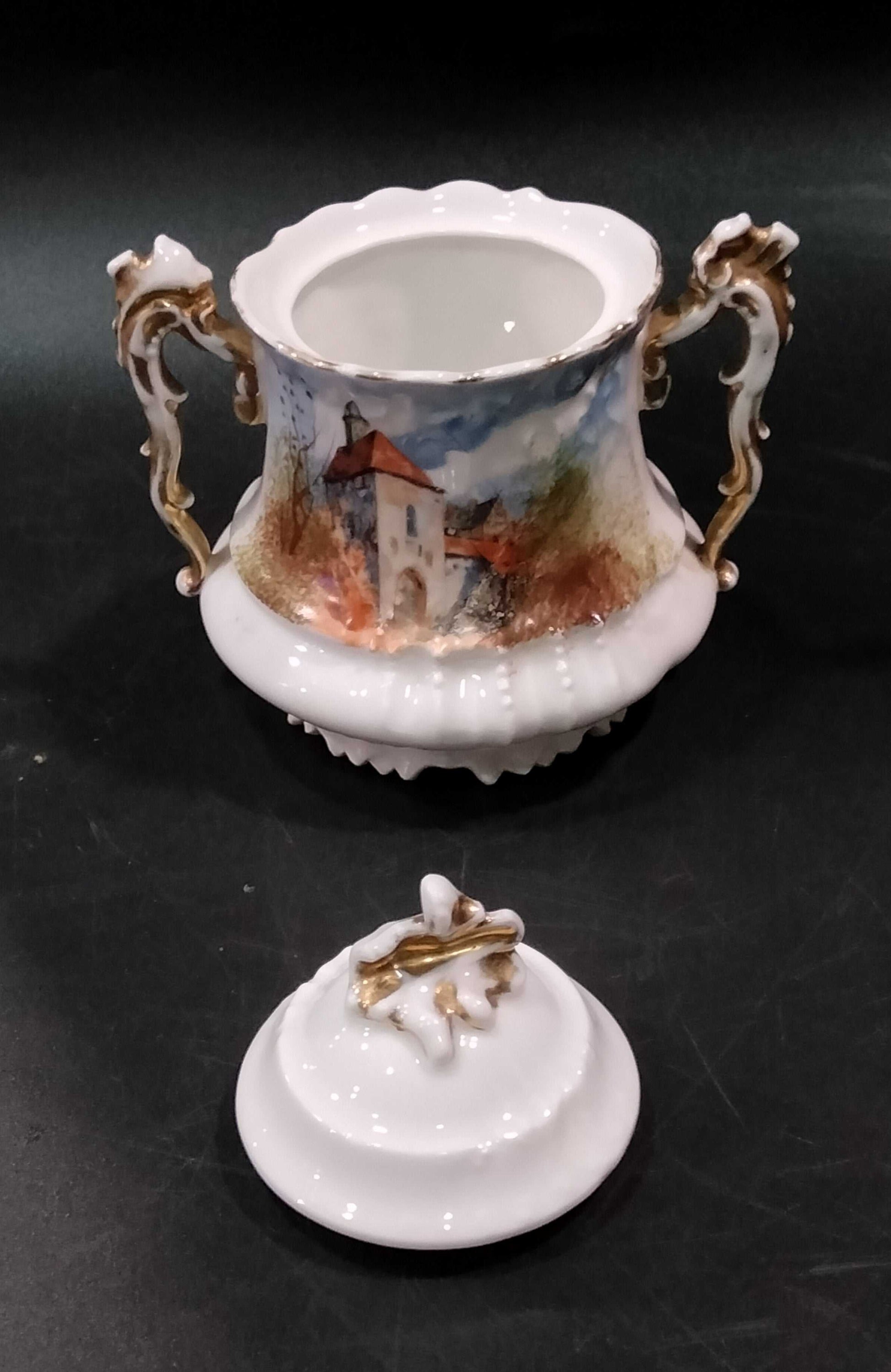 Azucarera de porcelana Limoges con tapa, parte del Juego de Café Tú y Yo, con asas ornamentadas y pintura de paisaje francés de época.