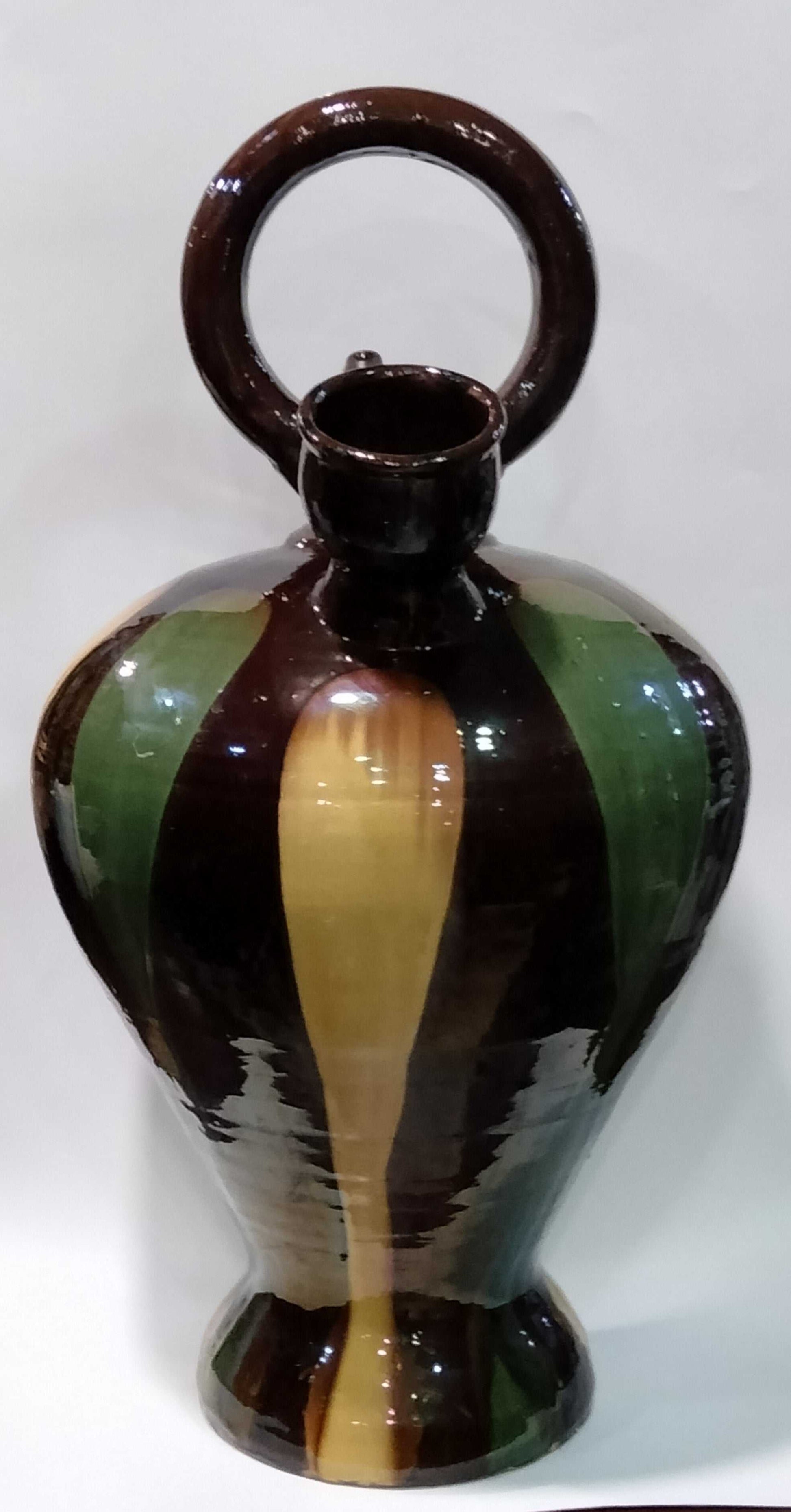 Botijo decorativo de tamaño grande con diseño pintado a mano en tonos marrón, verde y amarillo. Ideal para decoración tradicional del hogar.