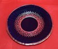 Plato de porcelana del Juego de Café Azul Cobalto con Hilo de Plata, decorado con elegante diseño clásico sobre fondo rojo. Ideal para decoración de mesa.