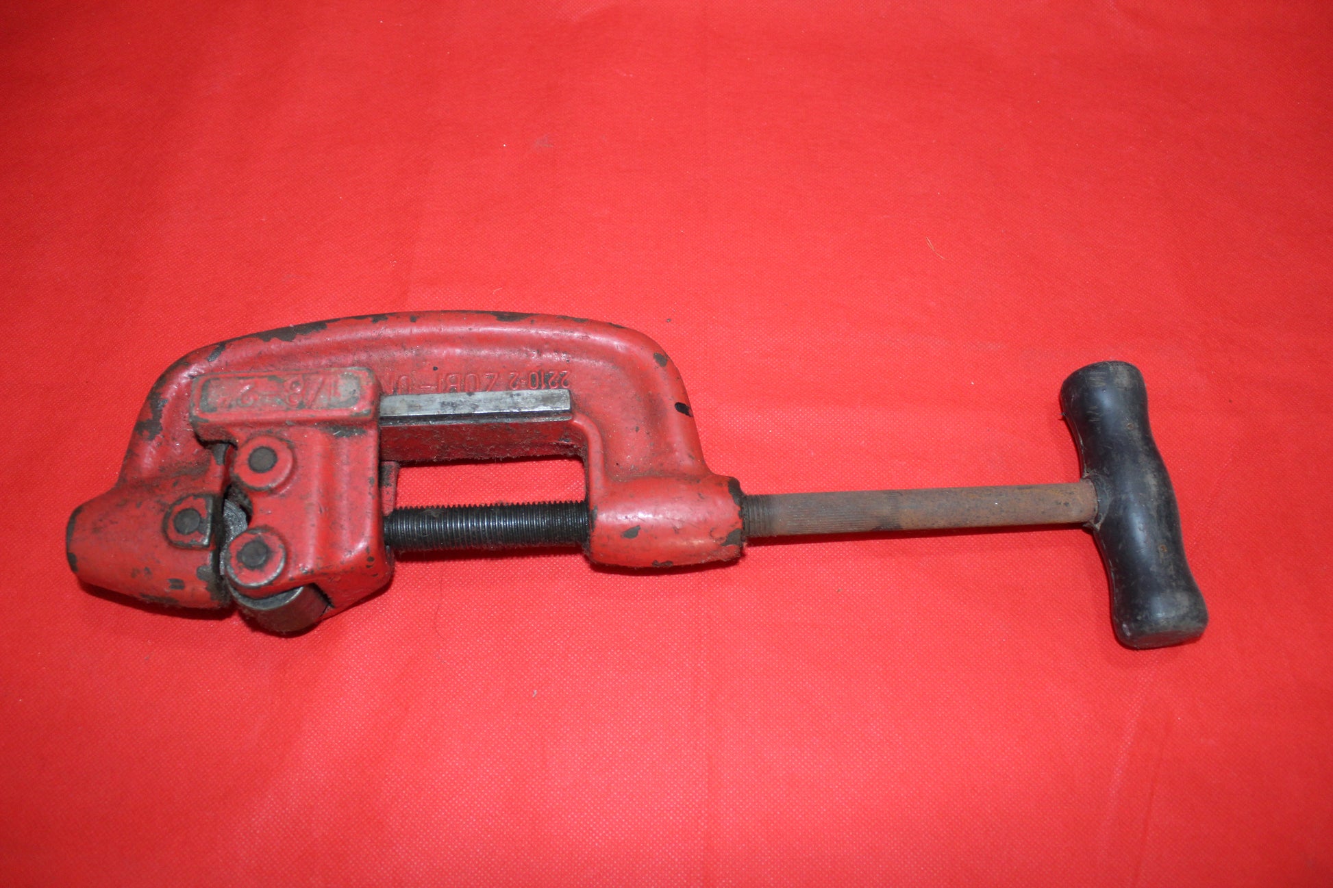 Cortatubo profesional antiguo en color rojo, ideal para cortes precisos en tuberías. Herramienta robusta y resistente para decoración vintage.