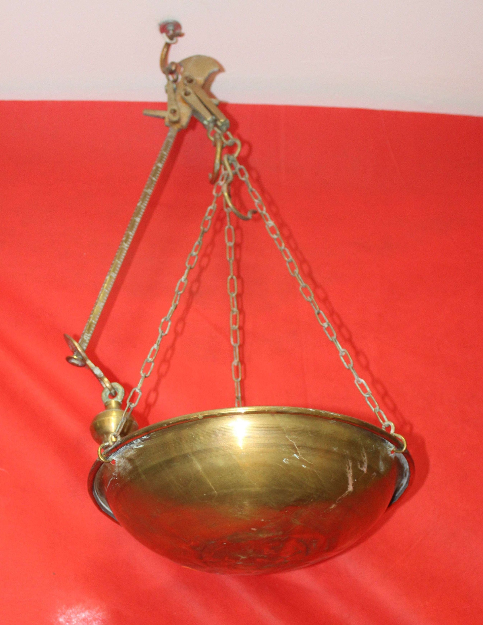 Romana de metal con plato colgante de bronce, ideal para decoración vintage en hogar o jardín. Artículo en excelentes condiciones.